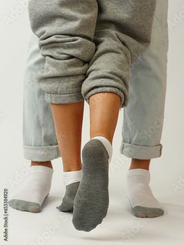 white and gray socks on man and woman feet closeup photo on white background
