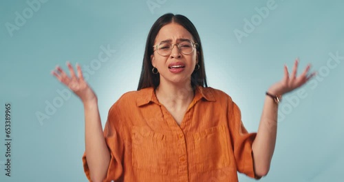 Confused, face and a woman with a shrug on a studio background for question, doubt or angry. Frustrated, stress and portrait of a young girl or designer with a gesture for a problem, mistake or fail photo
