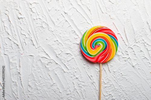 Bright multicolored lollipop on a white background. top view. sweets for the holiday. There is an empty space on the right for placing text or something else.