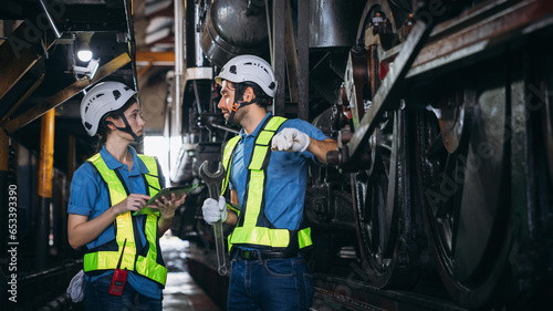 Industrial engineers inspect and perform maintenance on the machines at factory machines. Teamwork in the Manufacturing Industry in the train garage.