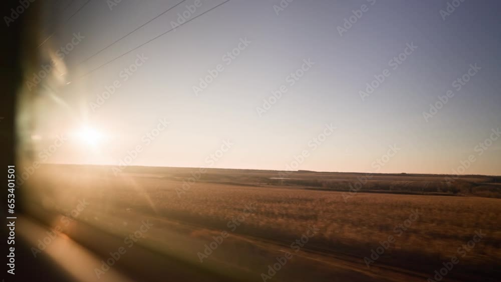 Bullet train rides on the railway track during a beautiful sunset. Journey and trip on train. Interior view at train's empty window.