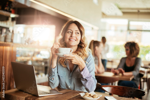 Young Caucasian woman enjoying a cup of coffee alone in a cafe or bar