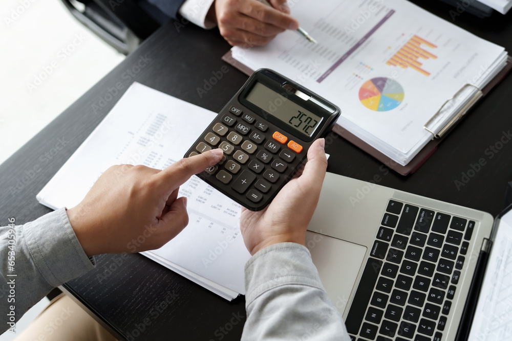 Business man analyzing data paperwork calculating numbers.