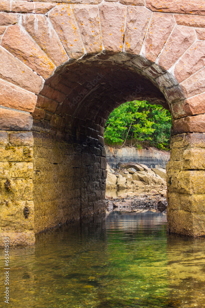 Arched bridge in Acadia national Park. Picture taken in the summer on a cloudy day while the tide was low.
