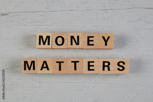 wooden blocks  in a white and grey board with the text money matters
