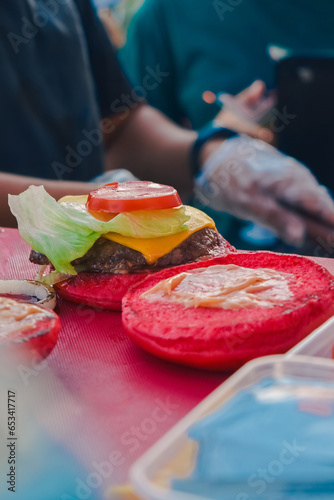 red burger topped with tomato, meat and cheese before frying (ID: 653417717)