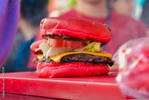 individual red burgers on the table with a blurred background (ID: 653417719)