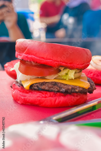 natural red burger, photography, filled with tomatoes, vegetables, meat and cheese on the table (ID: 653417762)