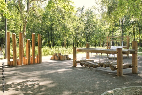 Wooden playground made of natural eco-friendly material in public city park. Modern safety children outdoor equipment. Concept of sustainable lifestyle and ecology. Children rest and games on open air