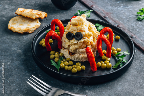Spider-shaped scrambled eggs with sausages. Funny halloween breakfast for kids