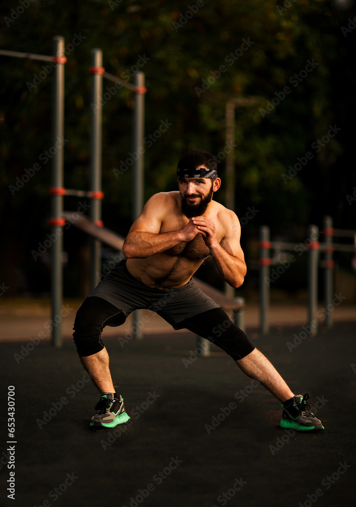 A young man with a beard ,doing sports on a street,sports ground
