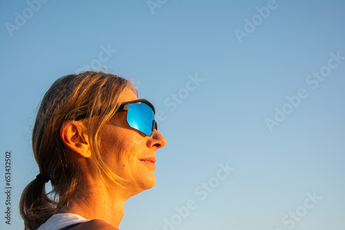 Portrait of woman with sunglasses on the sky background