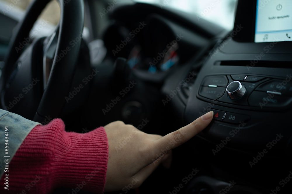 Girl's Hands Pressing the Hazard Warning Lights Button in a Car Girl's Hands Pressing the Hazard Warning Lights Button in a Car