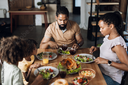 African American family having Thanksgiving dinner at dining table
