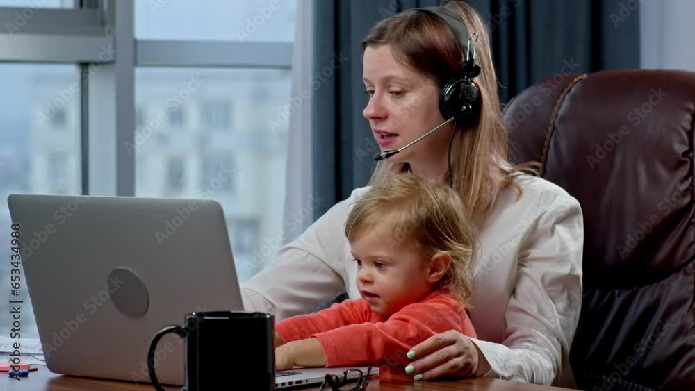 Woman with toddler working from home, trying to be mother and earn some money. Developer working from home, conference call with colleagues and child trying to play with mom