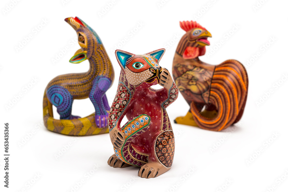 Vista de tres alebrijes distintos sobre fondo blanco, artesanías