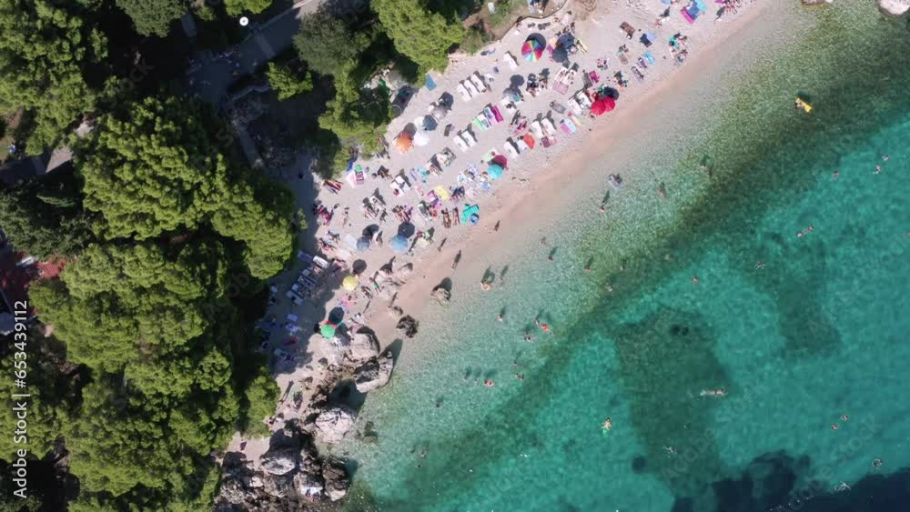 Typical pebble beach in Croatia on a busy day. Beaches narrow stretch