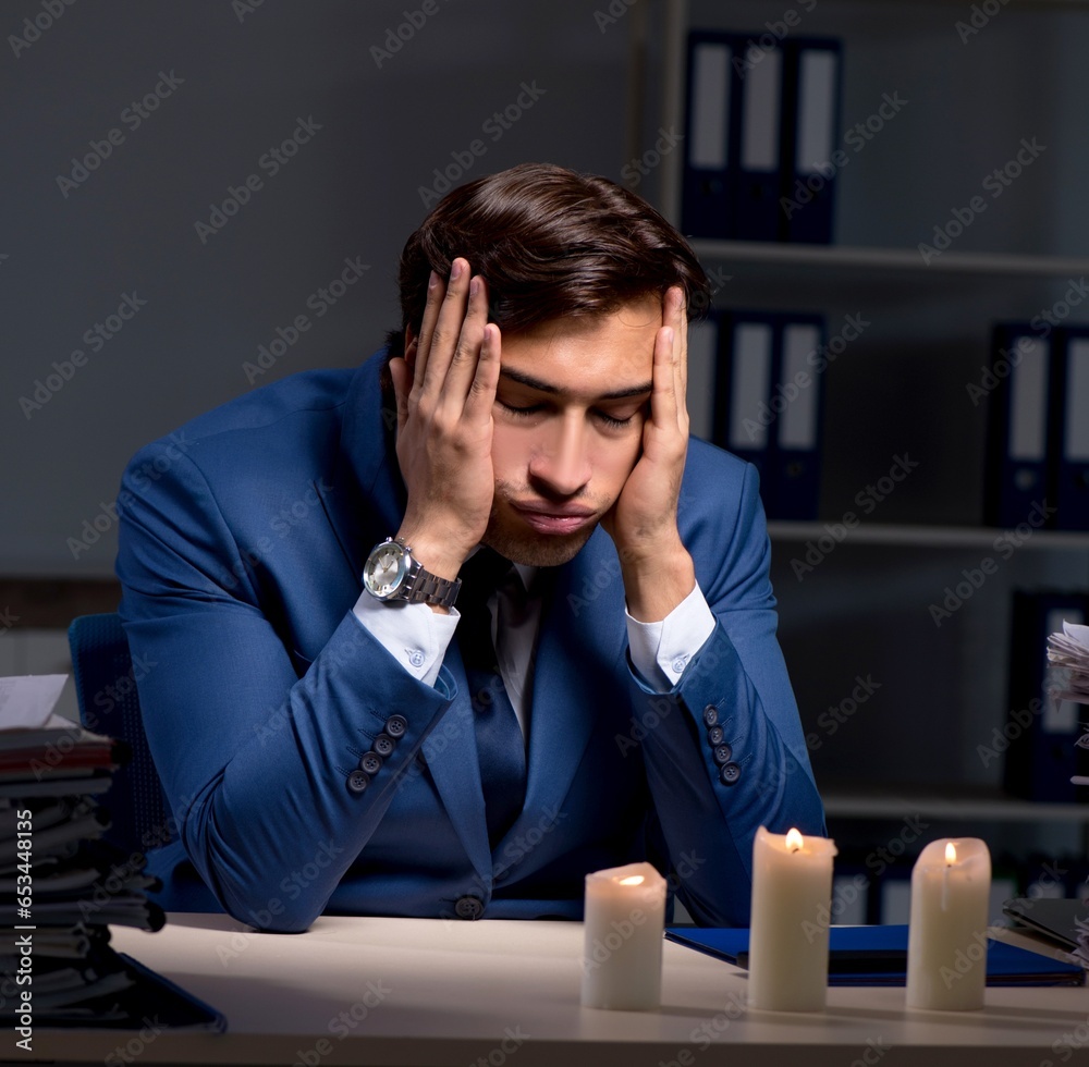 Businessman working late in office with candle light Businessman working late in office with candle light