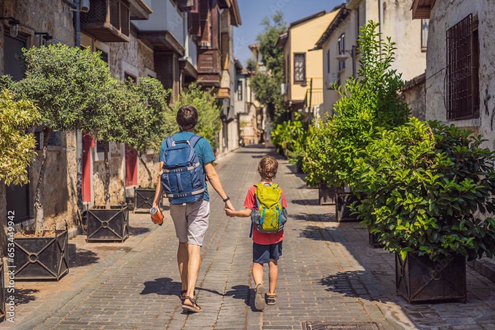 Happy father and son tourists on background of old street of Antalya. Traveling with kids concept. male tourist traveler discover interesting places and popular attractions and walks in the old city