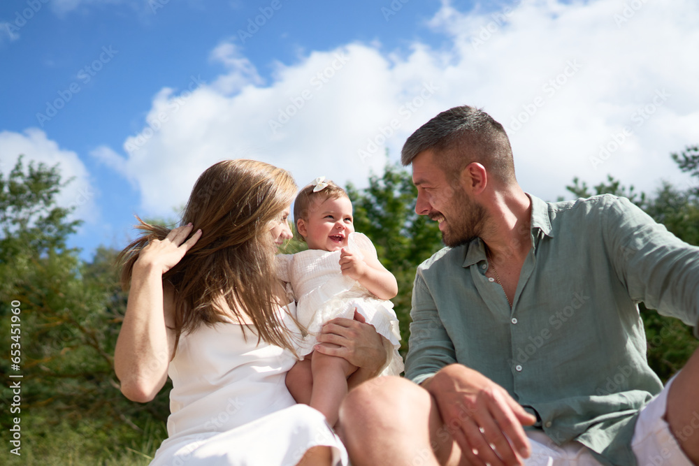 The white Caucasian family relaxing on the beach with their 1 year old baby girl. Latvia