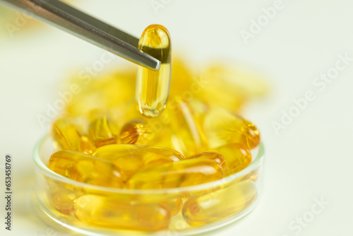 Golden capsules, omega 3, supplements, modern laboratory, chemical tests photo