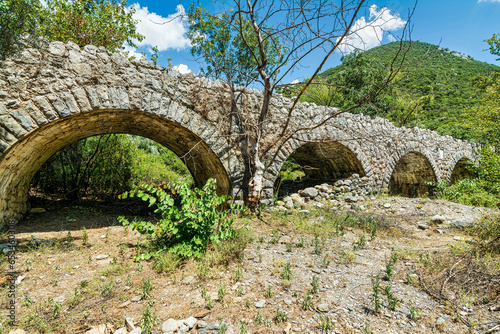 View of the traditional stone bridge of Agios Polykarpos in the western Taygetos, Greece, in summer.