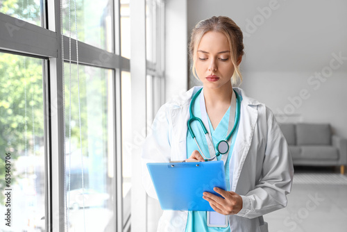 Female doctor writing in cl...