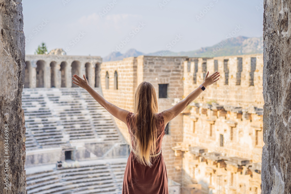 Woman tourist explores Aspendos Ancient City. Aspendos acropolis city ruins, cisterns, aqueducts and old temple. Aspendos Antalya Turkey. turkiye