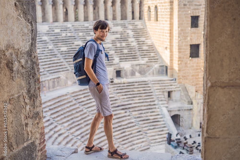 Man tourist explores Aspendos Ancient City. Aspendos acropolis city ruins, cisterns, aqueducts and old temple. Aspendos Antalya Turkey. turkiye Man tourist explores Aspendos Ancient City. Aspendos acropolis city ruins, cisterns, aqueducts and old temple. Aspendos Antalya Turkey. turkiye
