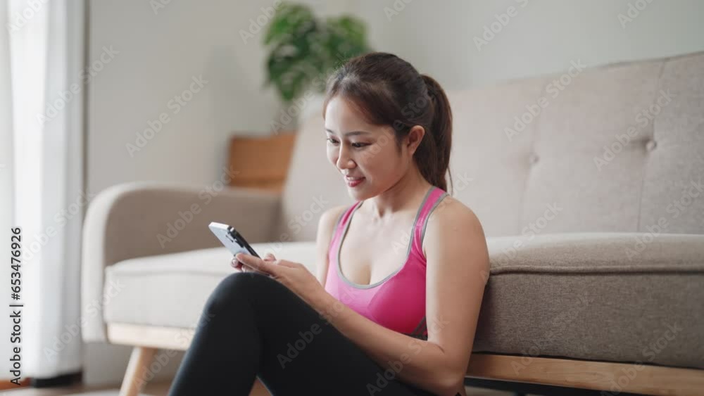 Attractive happy woman training gym at home holding smartphone . Attractive happy woman training gym at home holding smartphone .