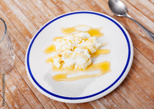 Portion of cottage cheese with sweet honey closeup