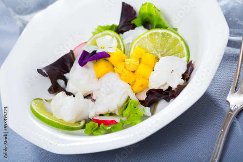 Seafood ceviche with hake, mango and lime garnished with edible flowers