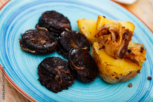 Fried rustic tasty blood sausage with potato served at plate, nobody photo