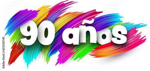 90 years at spanish paper word sign with colorful spectrum paint brush strokes over white.