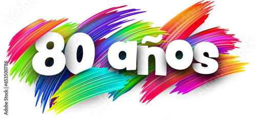 80 years at spanish paper word sign with colorful spectrum paint brush strokes over white.