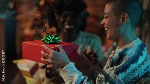 Young lesbian couple opening presents they got each other during the Christmas holidays at home