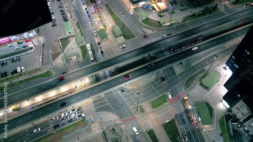 Aerial drone night video of illuminated Crossroad, multi lane highway through urban city center popular multilevel junction