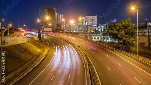 Long exposure time-lapse of street traffic near Campolide station in the evening with car lights trails. Lisbon, Portugal. Zoom in effect photo