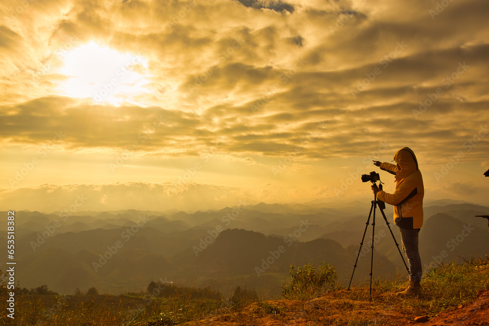 Sunset Silhouette: Professional photographer capturing the beauty of nature with camera and tripod amidst the breathtaking sunset backdrop Sunset Silhouette: Professional photographer capturing the beauty of nature with camera and tripod amidst the breathtaking sunset backdrop