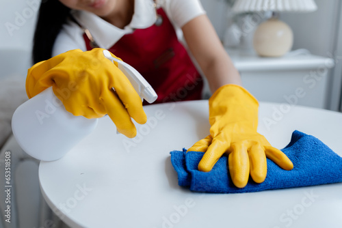 Asian woman cleaning staff  housekeeper cleaning tables in a company office  maintaining cleanliness in the office. Cleaning concept and housekeeper taking care of cleanliness and order in the office.