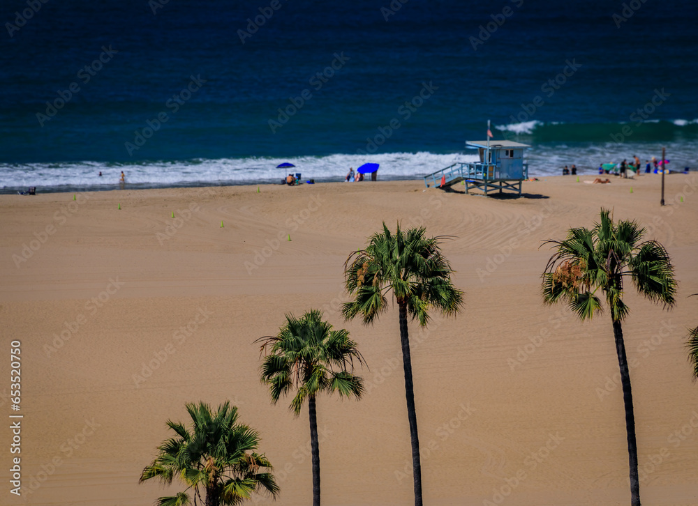 Beach and Pacific Ocean in Santa Monica, a famous tourist destination in Los Angeles California, USA with sand volleyball courts and palm trees
