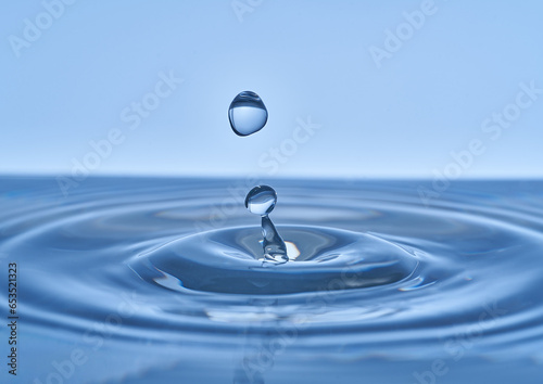 Group of water droplets fall and bounce on a water surface