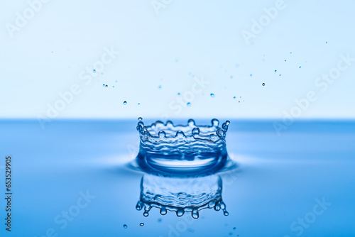 Group of water droplets fall and bounce on a water surface