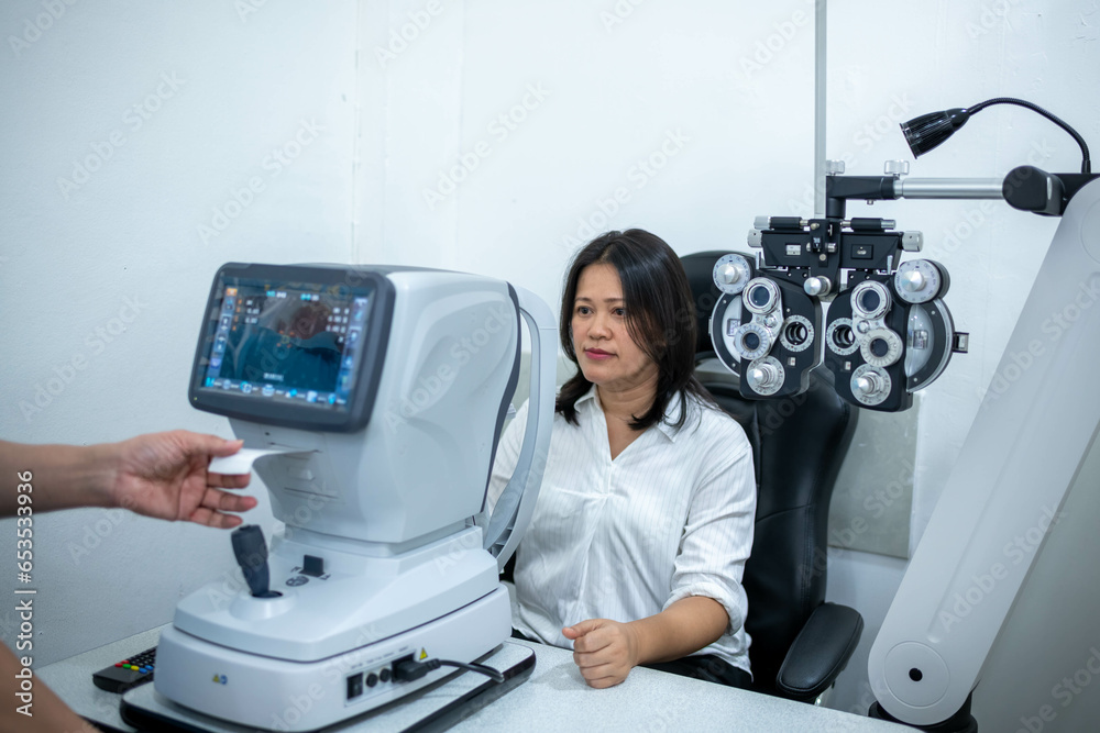 Obraz premium Woman optical shop customer doing eyesight measurement with optical phoropter check eye distance for eyeglasses is optical eye shop service.