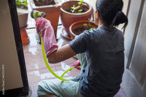 Picture of a woman watering plants on the balcony of a house