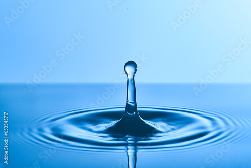 Group of water droplets fall and bounce on a water surface