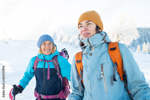 Two women walk in the winter trekking