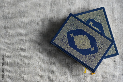 The Quran, also romanized Qur'an or Koran, is central religious text of Islam, believed by Muslims to be revelation from God (Allah). Classical Arabic. Sack, blue. photo