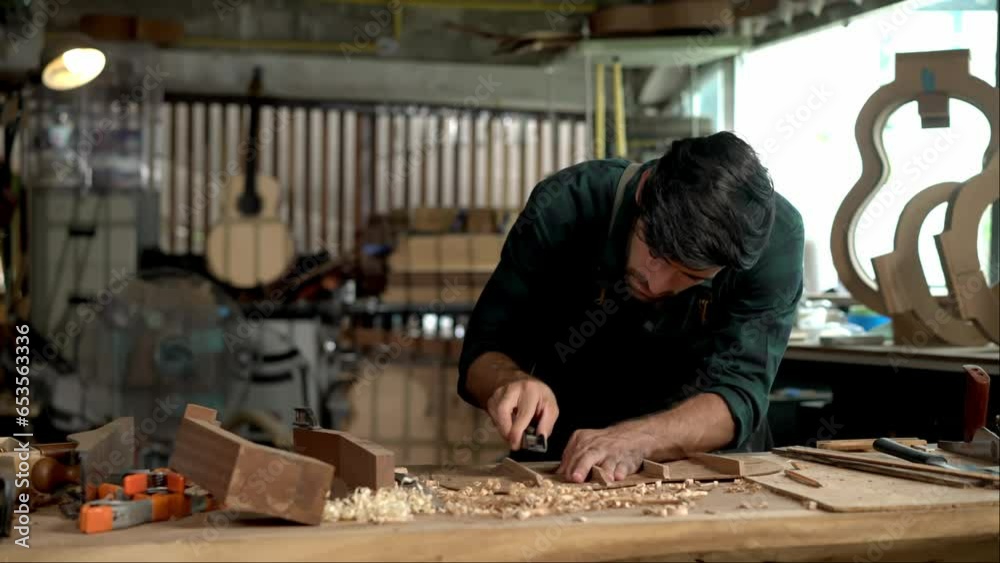 Guitar luthier using small planer to fine-tune bracing of acoustic guitar Guitar luthier using small planer to fine-tune bracing of acoustic guitar