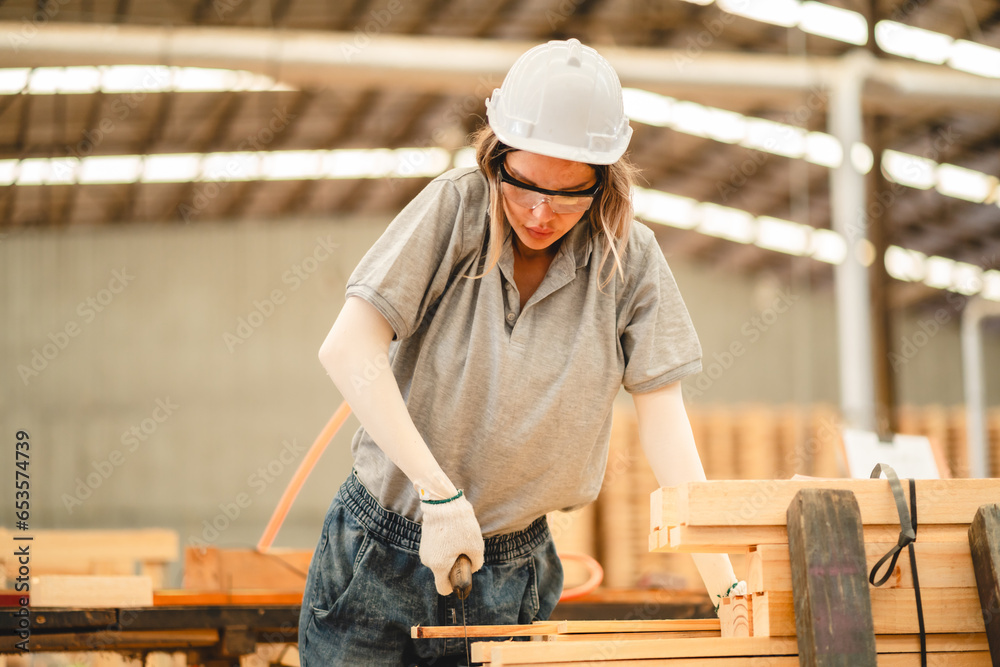 woman carpenter worker wearing safety uniform working to quality control checking of wooden products at workshop manufacturing. female technician making wooden in carpenter's shop industry warehouse. woman carpenter worker wearing safety uniform working to quality control checking of wooden products at workshop manufacturing. female technician making wooden in carpenter's shop industry warehouse.